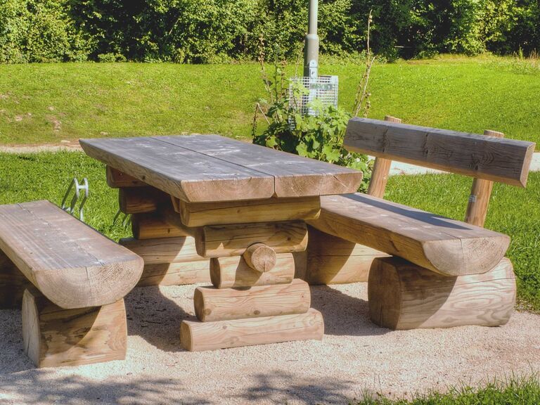 Gartengarnitur aus Stammholz mit massivem Gartentisch und Gartenbänken aus Holz für Terrasse und Garten