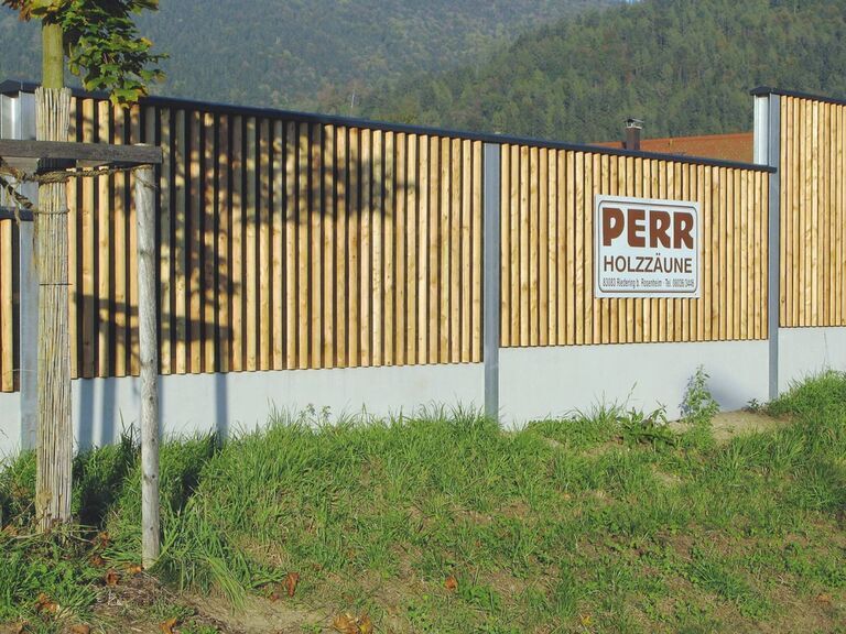 Hochabsorbierende Lärmschutzwand mit senkrechten halbrunden Latten in Lärche natur auf Betonsockel montiert