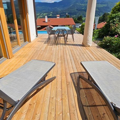 Nutzung einer Holzterrasse aus L&auml;rche mit sch&ouml;ner Aussicht