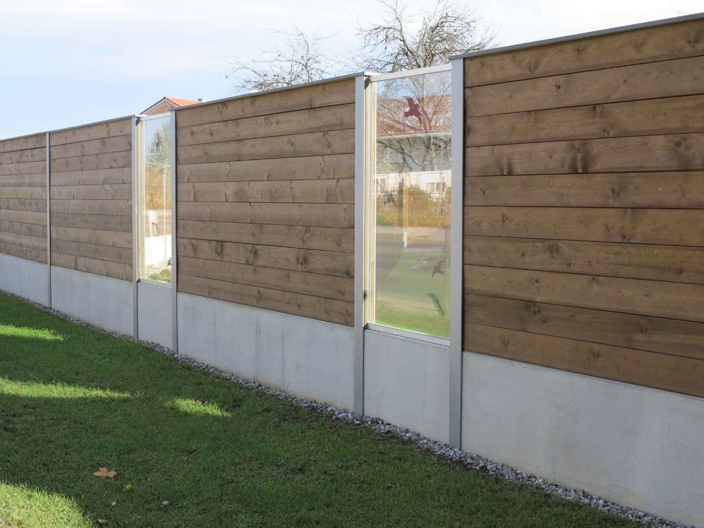 Reflektierende Bohlen-Lärmschutzwand aus Holz mit integriertem Glaselement für Schallschutz und eine offene Gestaltung