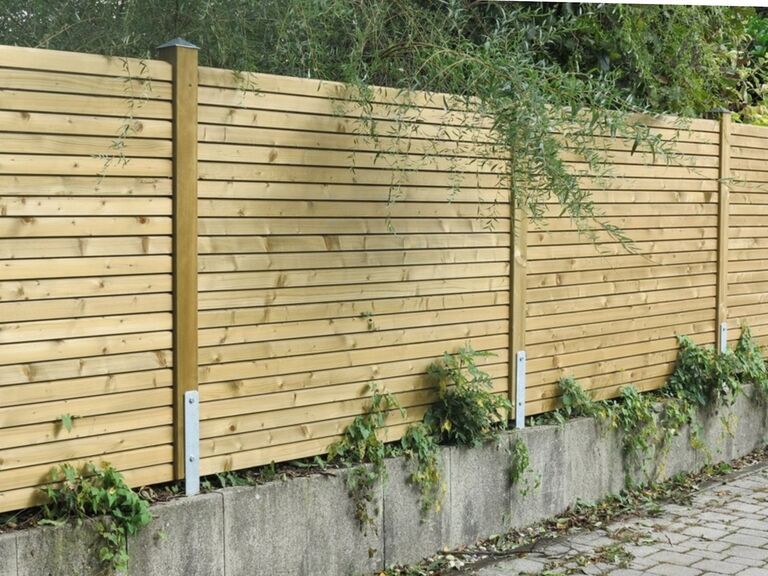 Sichtschutzwand aus waagrechten Rhombuslatten in Fichte kesseldruckimprägniert zwischen Holzsäulen montiert