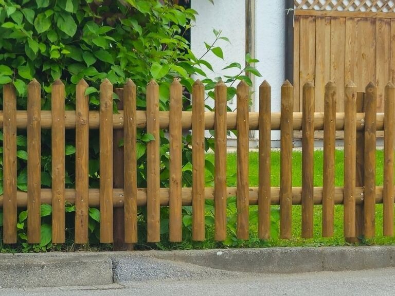 Staketenzaun aus halbrunden Holzstaketen als natürlicher und luftiger Gartenzaun