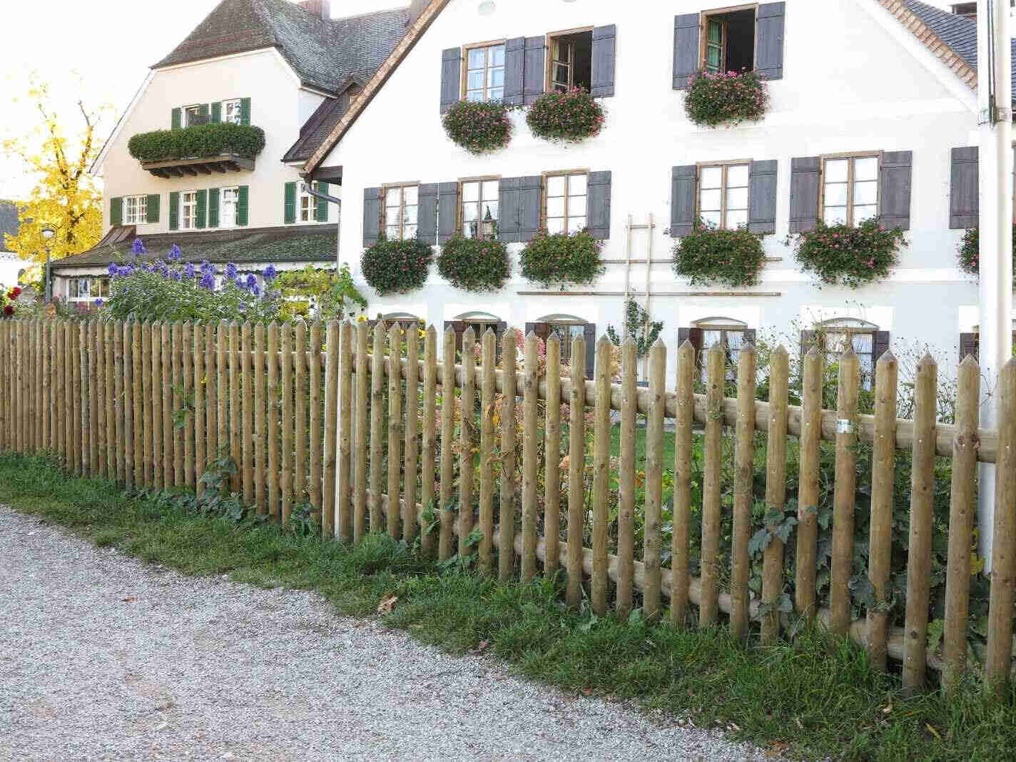 Staketenzaun mit zeitloser Optik f&uuml;gt sich harmonisch in naturnahe Garten- und Landschaftsgestaltung ein